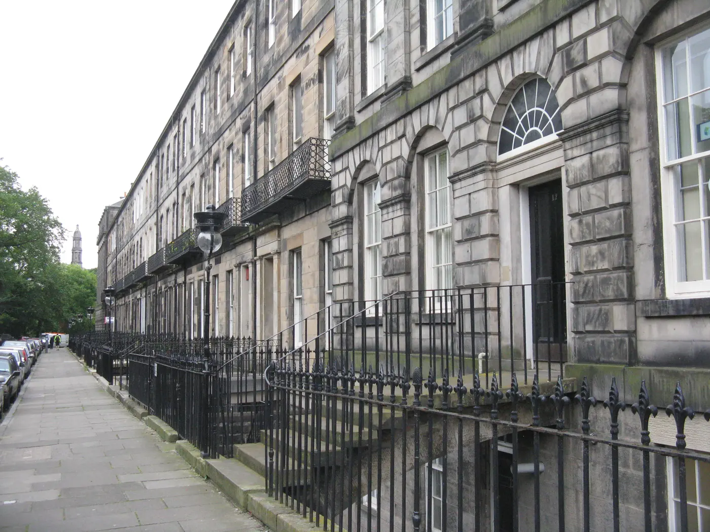 Houses on Fettes Row in Edinburgh New Town seen from the pavement, showing railings, steps to the main doors and sash and case windows.